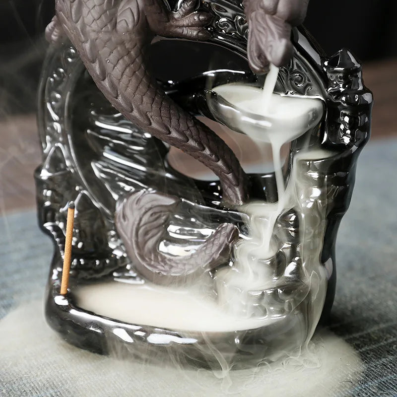 Decorative candle holder with dragon design emitting smoke on a textured surface.