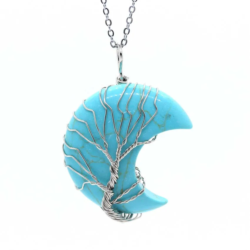 Turquoise crescent moon pendant with silver tree design on a white background