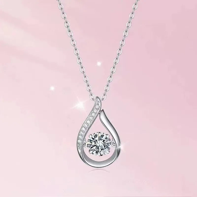 Silver teardrop-shaped pendant with a diamond on a pink background