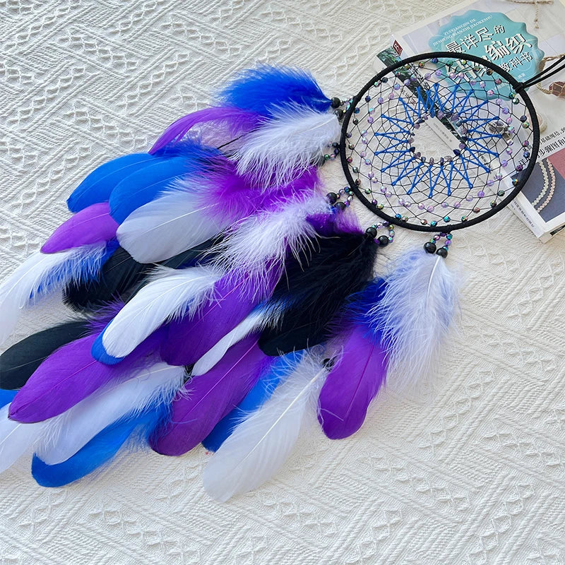 Dreamcatcher with blue, purple, and white feathers on a textured surface