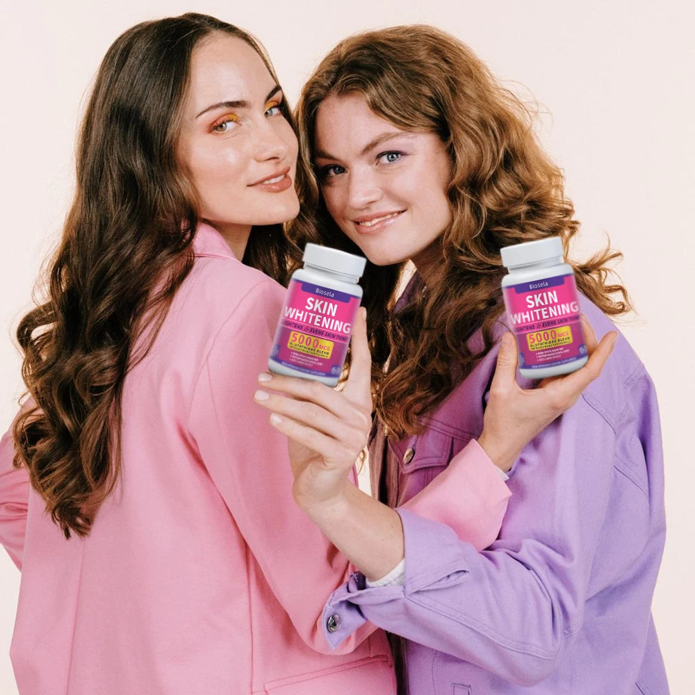 Two women holding skin whitening product containers against a plain background