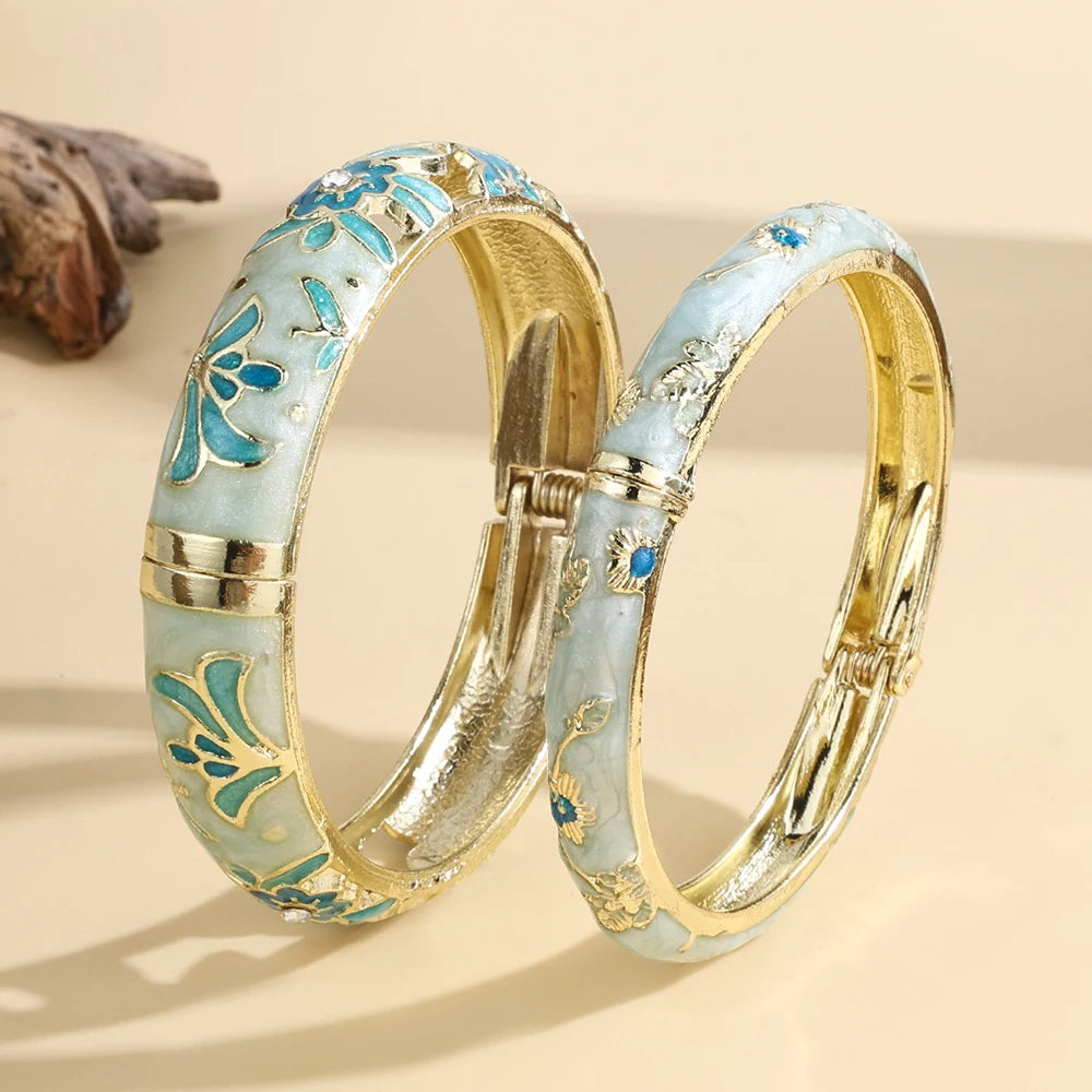 Two gold and turquoise bangles on a beige background
