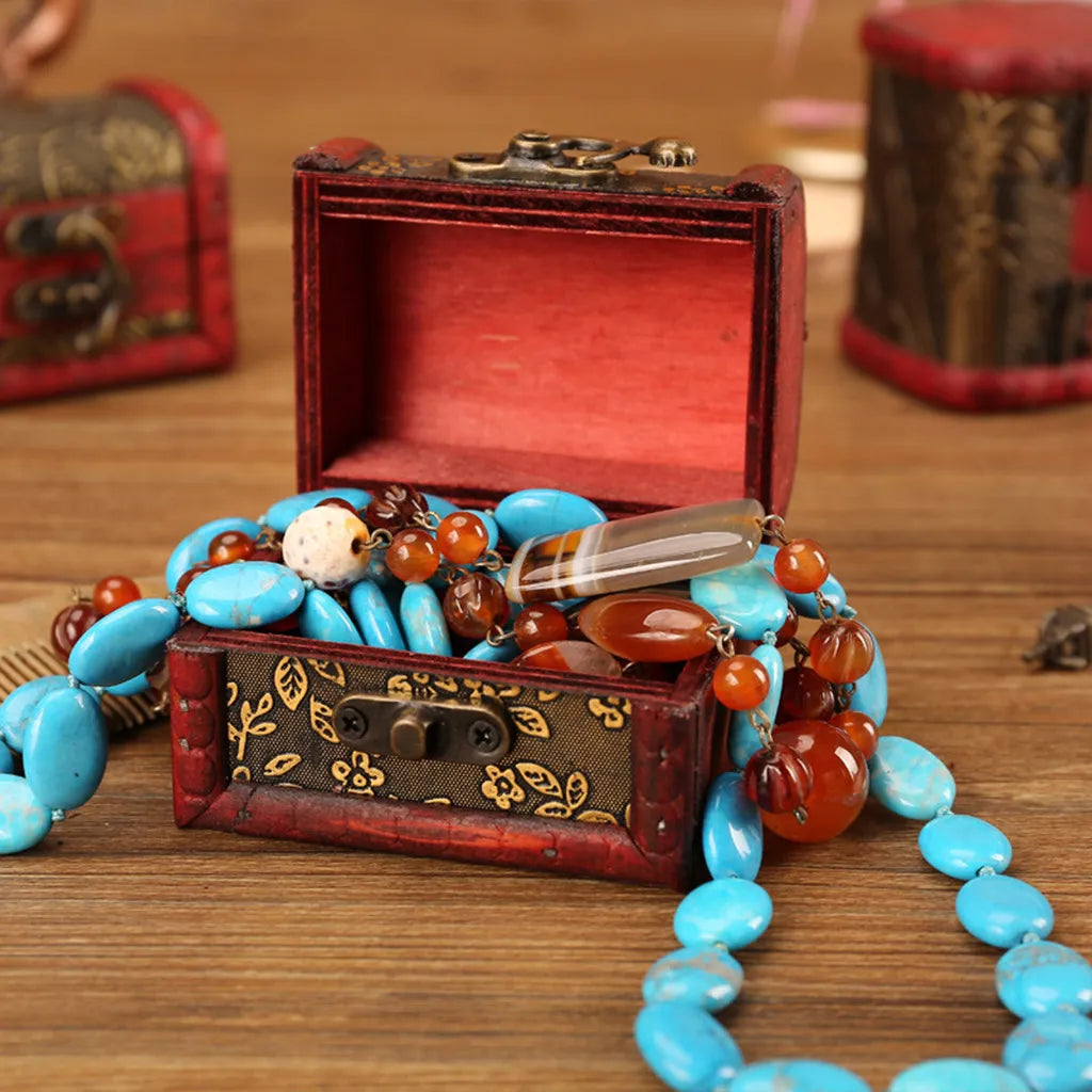 Decorative jewelry box with beads on a wooden surface