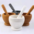 Set of mortar and pestle with different materials on a white background