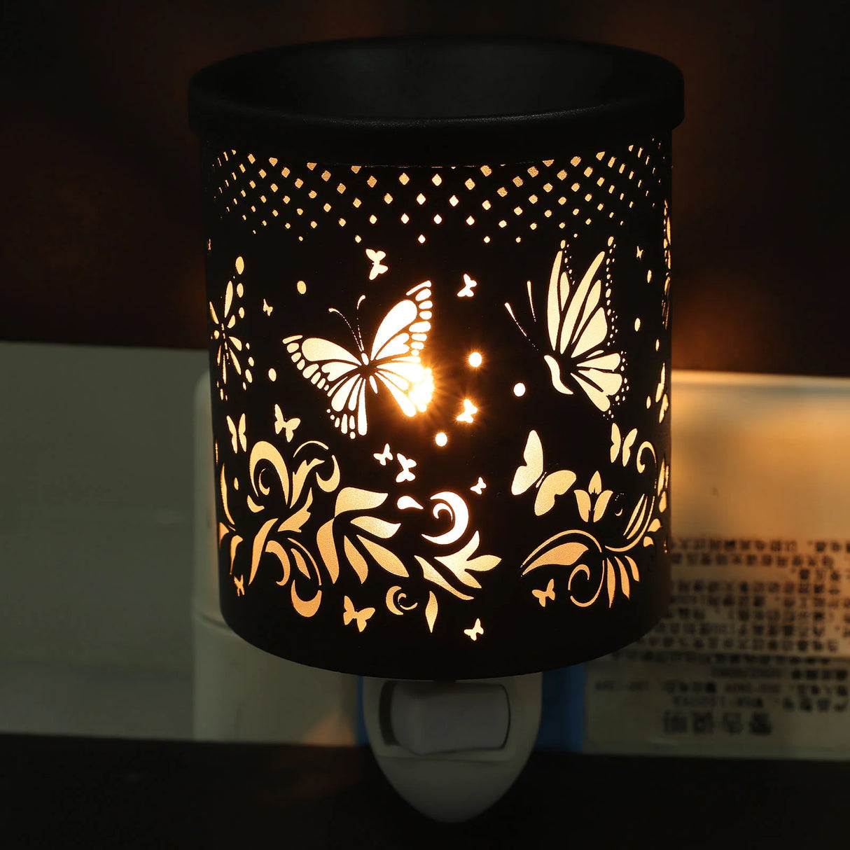 Decorative night light with butterfly patterns on a dark background
