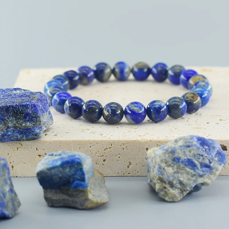 Lapis lazuli beaded bracelet with raw lapis stones on a light gray background