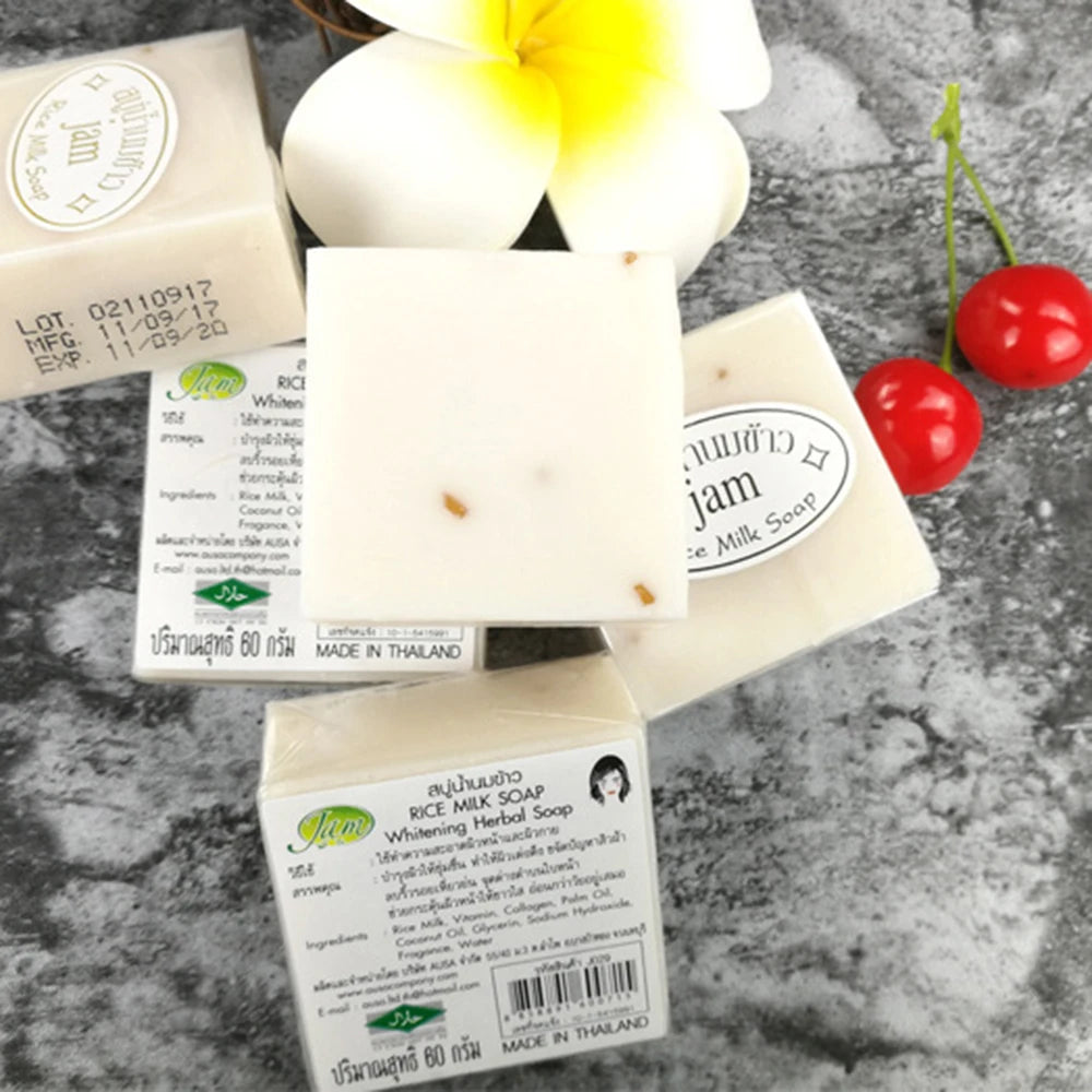 Rice milk soap bars with labels on a gray surface with flowers and cherries.
