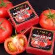 Two boxes of LKIAE Tomato Bar Soap with fresh tomatoes on a dark background