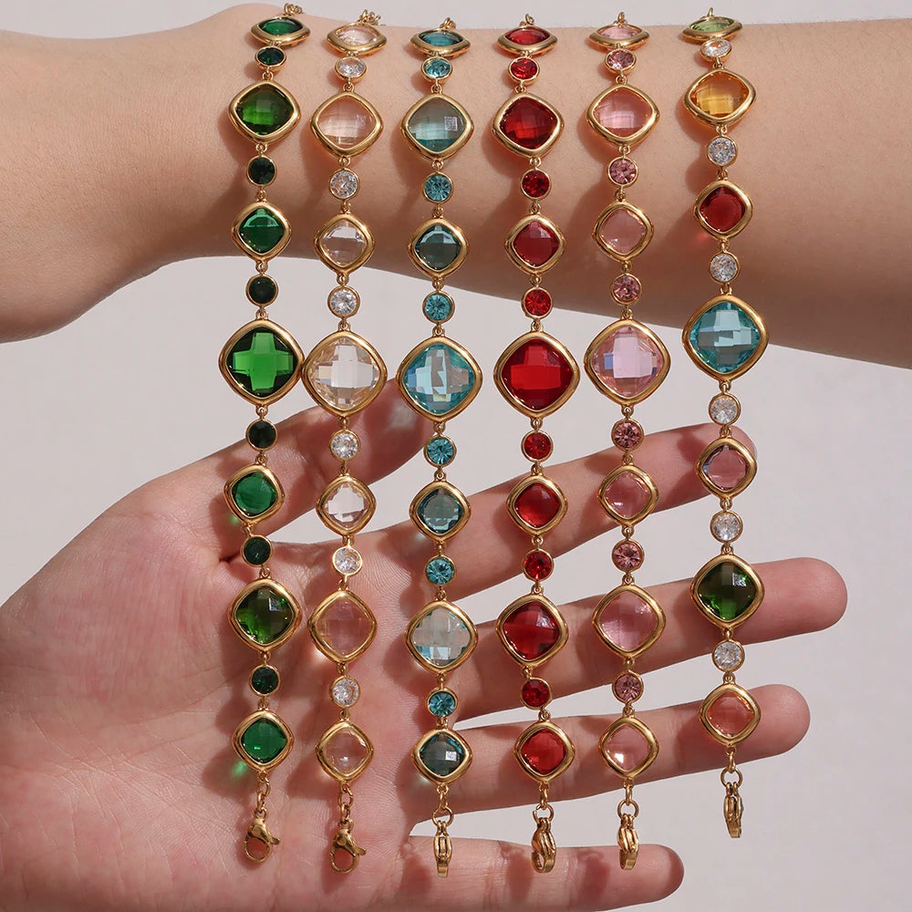 Colorful gemstone necklaces on a hand against a neutral background