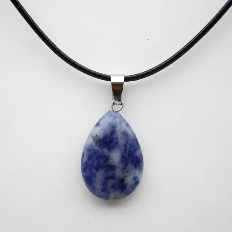 Teardrop-shaped blue stone pendant on a black cord against a white background