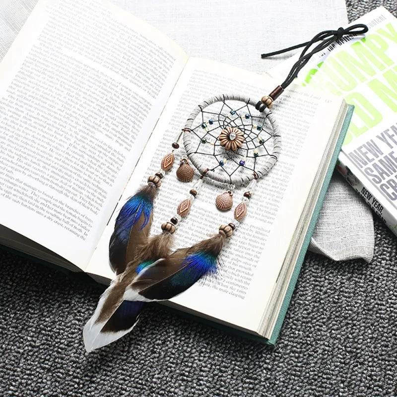 Dreamcatcher with feathers on an open book