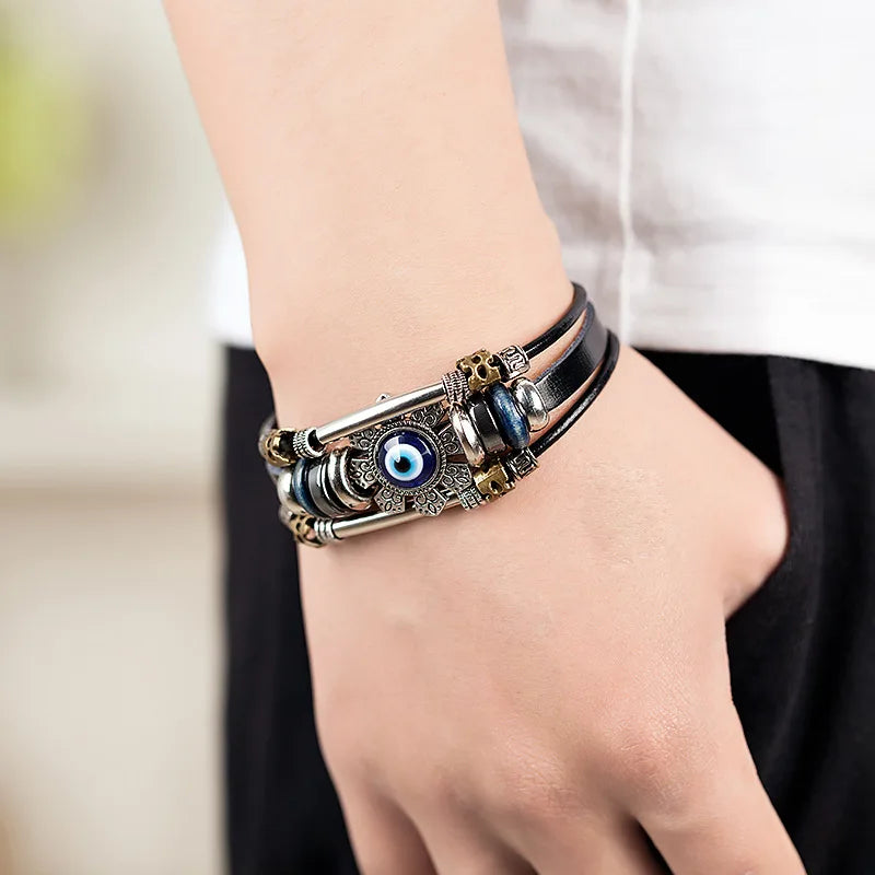 Close-up of a hand wearing a decorative bracelet with an evil eye design.