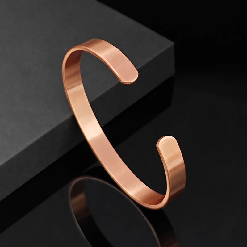 Rose gold bracelet on a black reflective surface