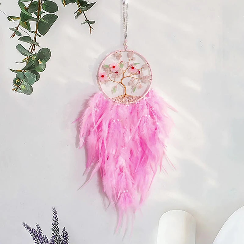 Pink feathered dreamcatcher with tree of life design on a white background