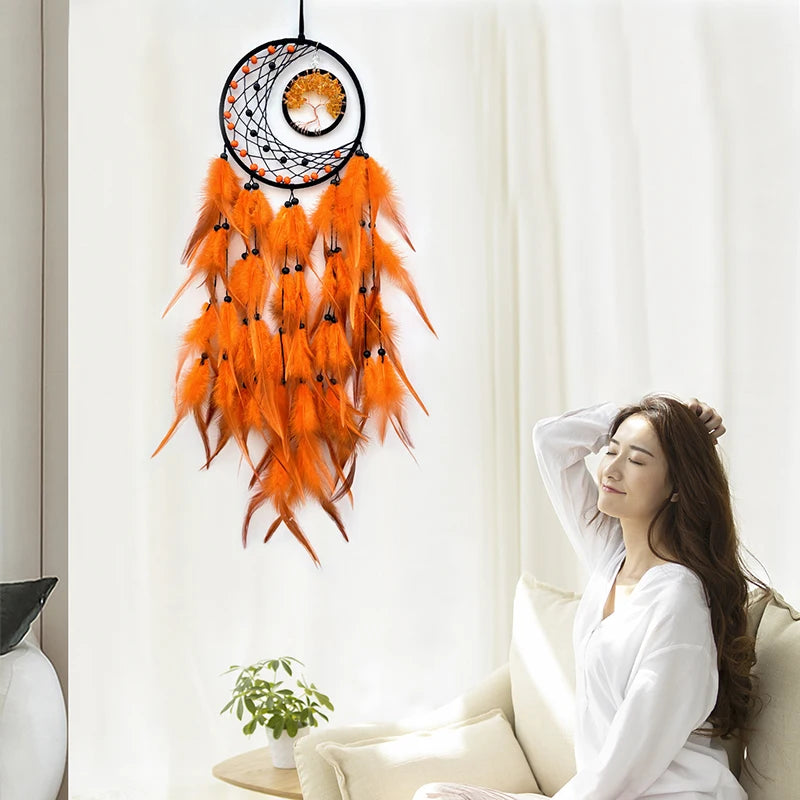Woman sitting on a couch with an orange dreamcatcher hanging behind her