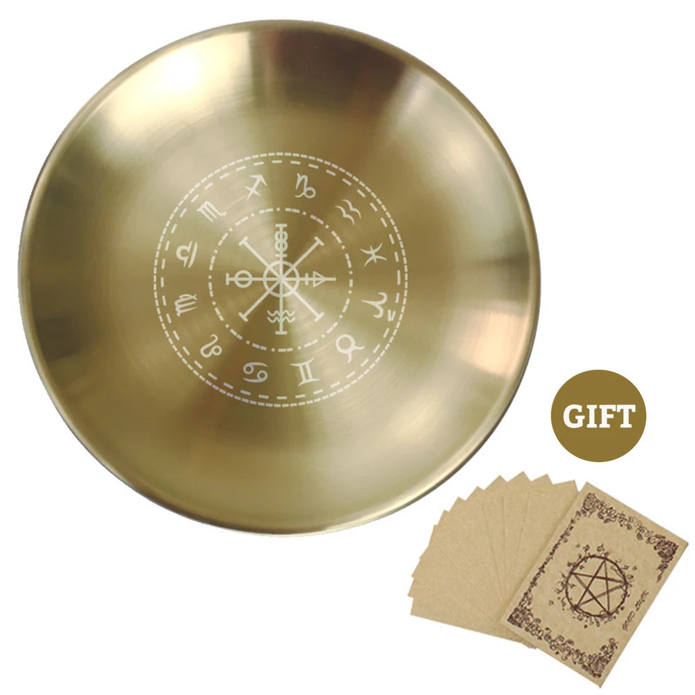 Gold dish with engraved symbols and brown cards on a white background