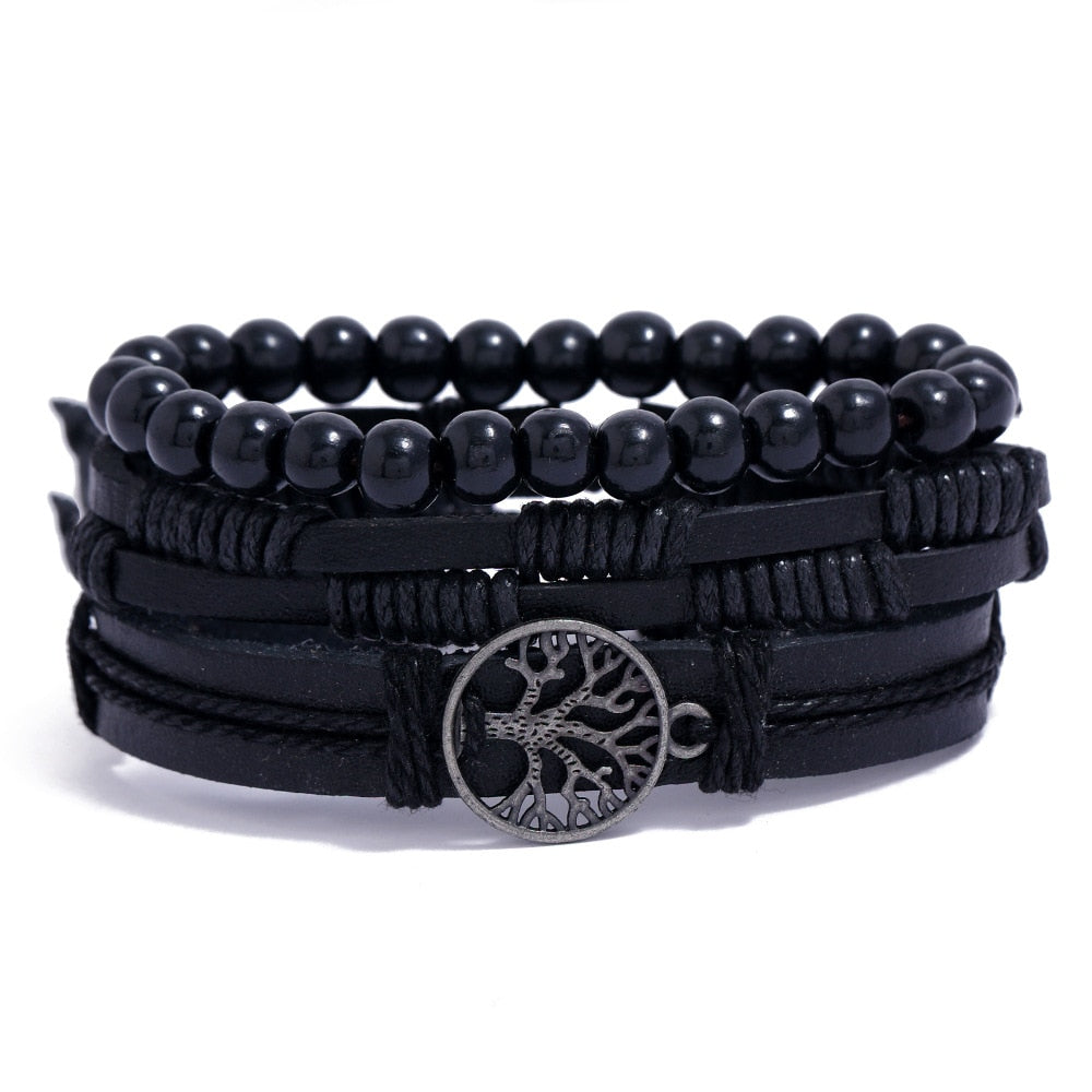 Black beaded and leather wrap bracelet with a tree of life charm on a white background