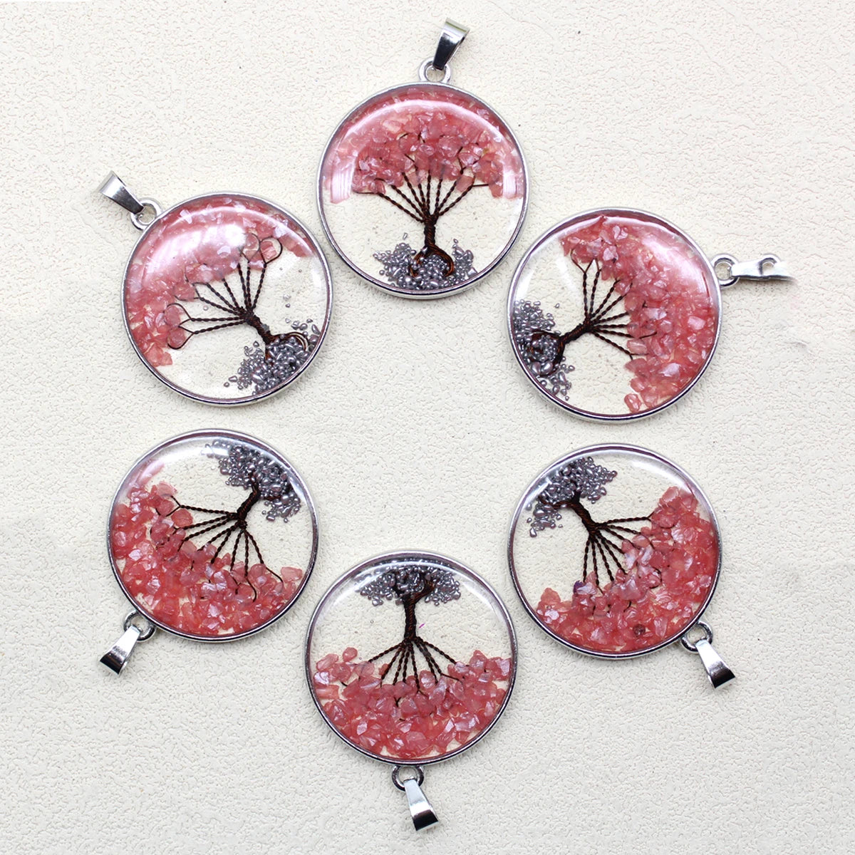 Set of six circular pendants with tree designs on a light gray background