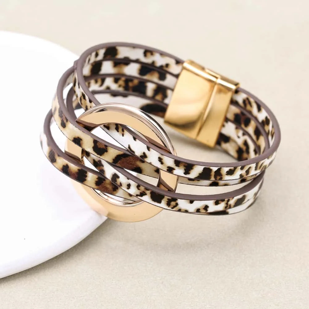 Leopard print bracelet with gold accents on a beige background