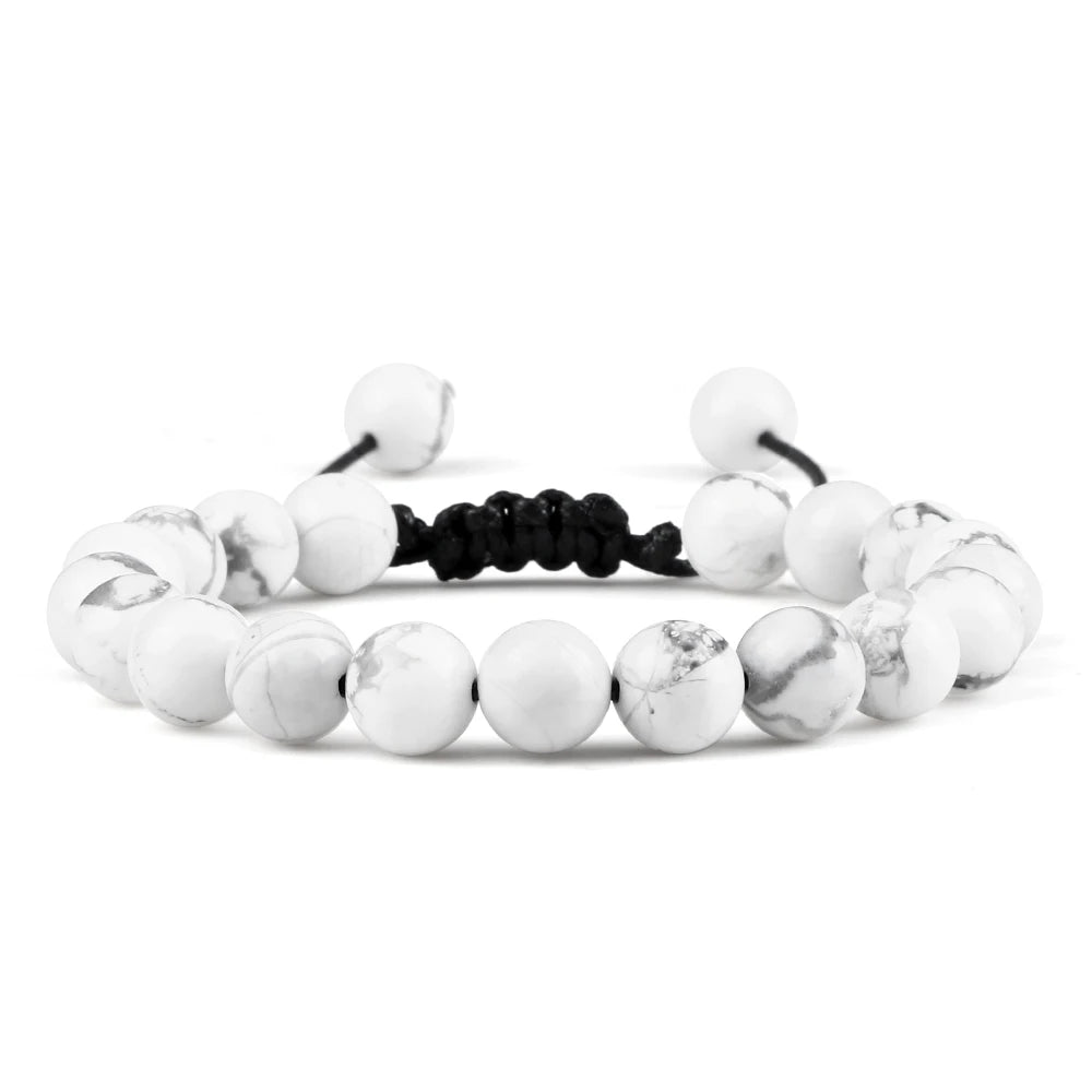 White beaded bracelet with black cord on a white background