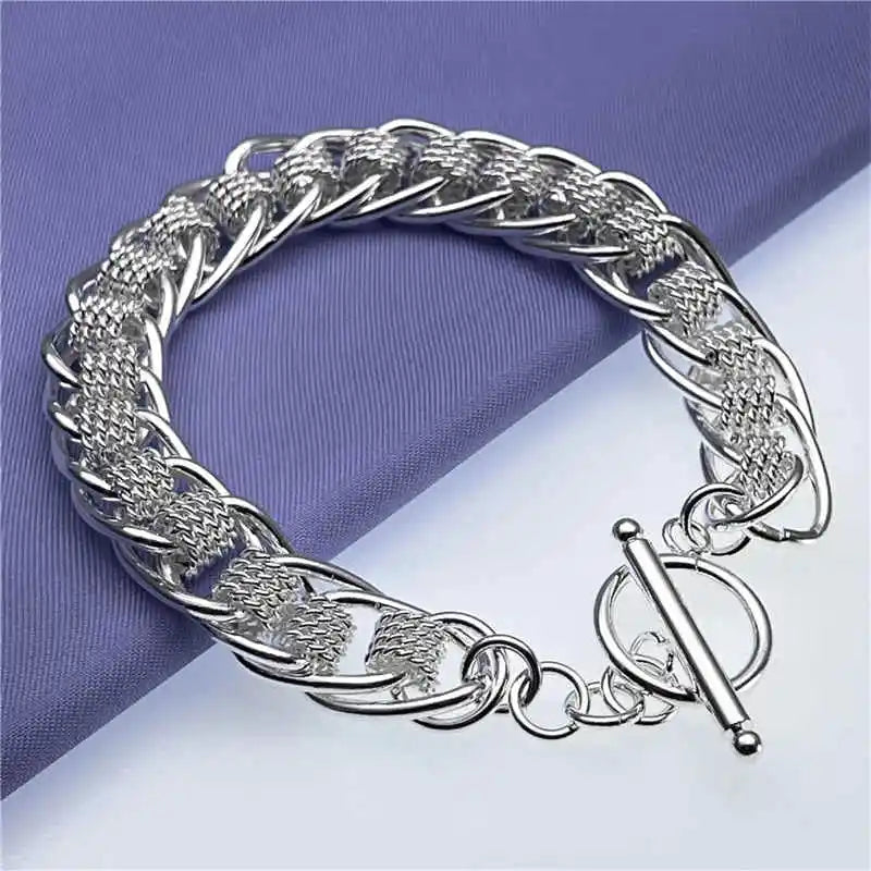 Silver braided bracelet on a purple and white background