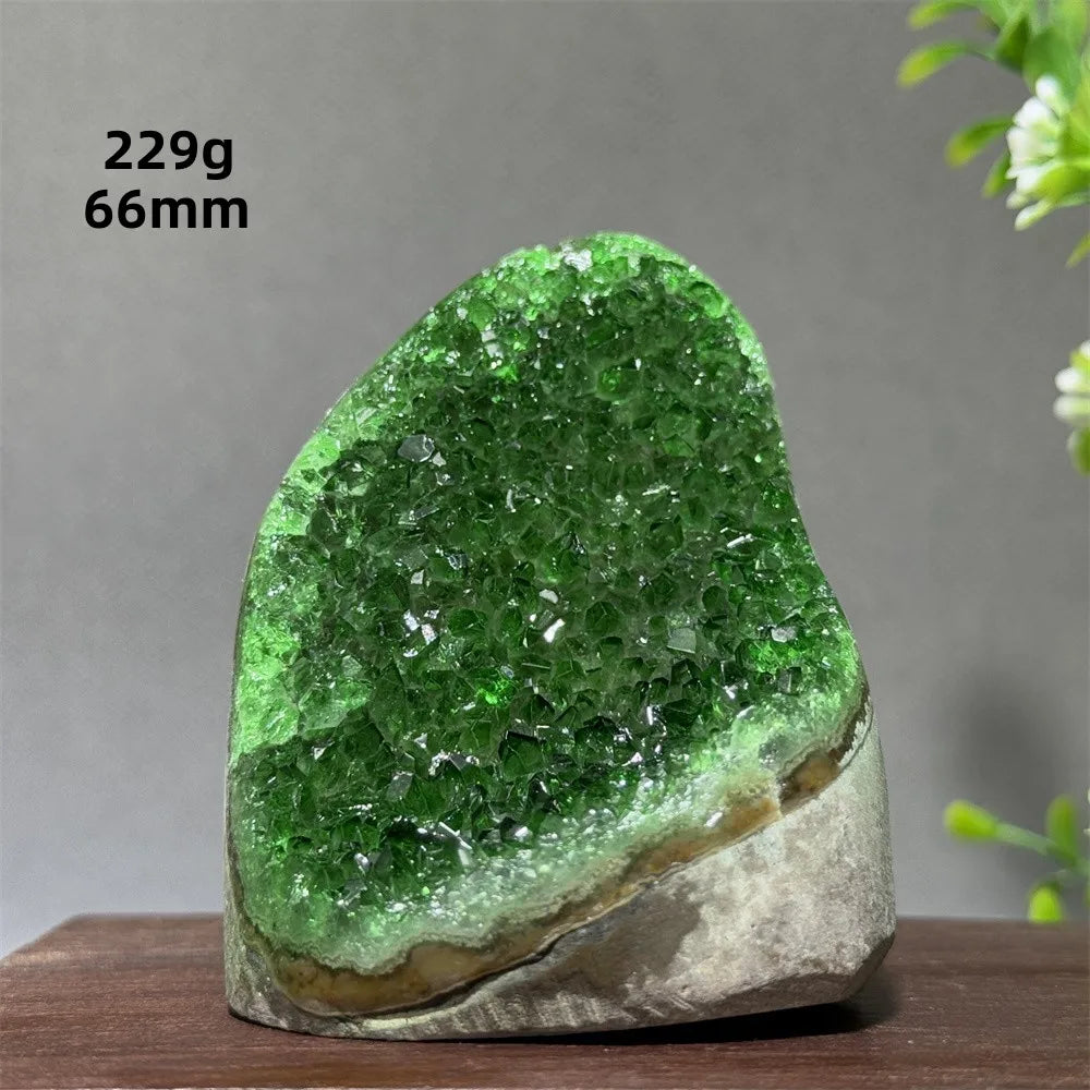 Green crystal rock on a wooden surface with measurements displayed