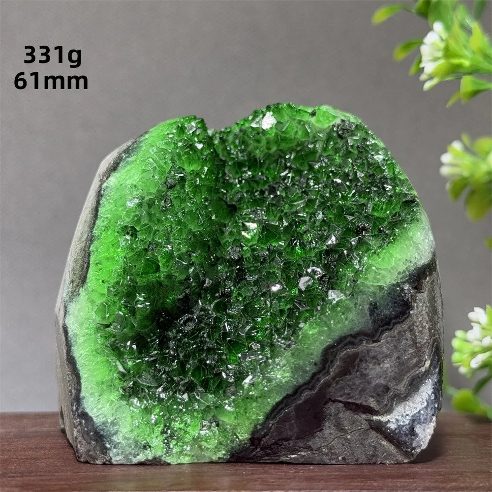 Green crystal rock on a wooden surface with a gray background