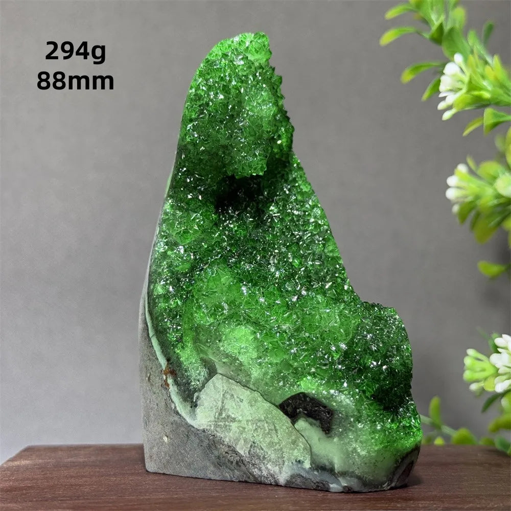 Green crystal rock on a wooden surface with a gray background