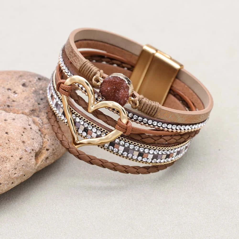 Multistrand bracelet with heart charm and gold clasp on a light background