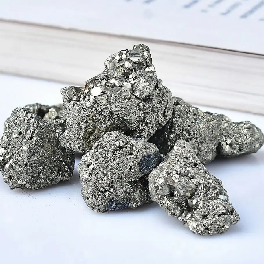 Pile of metallic pyrite crystals on a white surface
