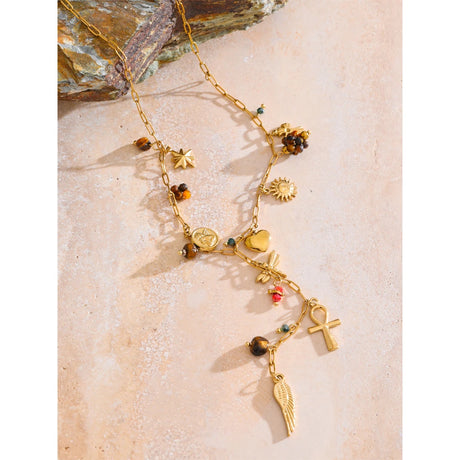 Gold necklace with various charms on a textured surface