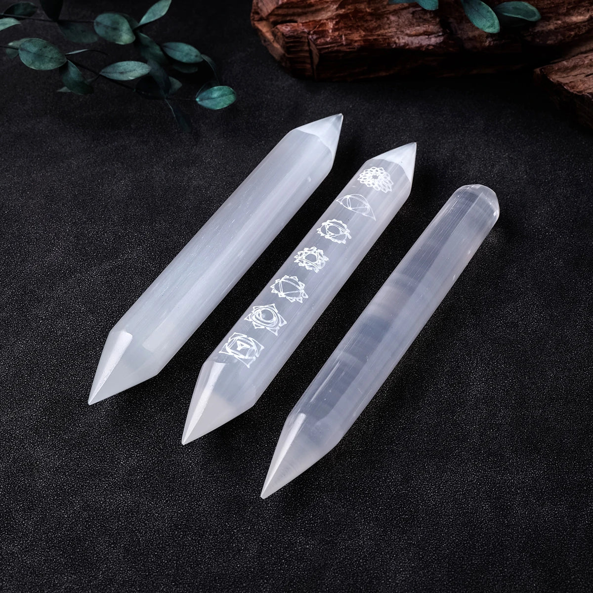 Three crystal sticks with engraved symbols on a dark surface