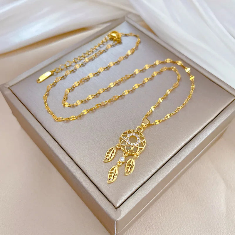 Gold necklace with a decorative pendant on a beige jewelry box