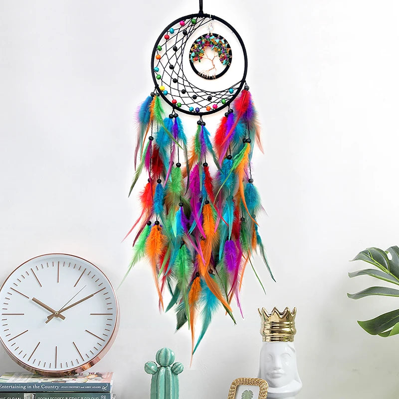 Colorful dreamcatcher with feathers hanging on a white wall next to decorative items.