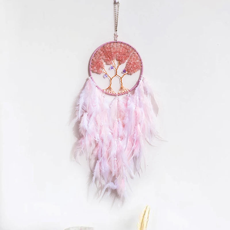 Pink feathered dreamcatcher with tree of life design on a white background