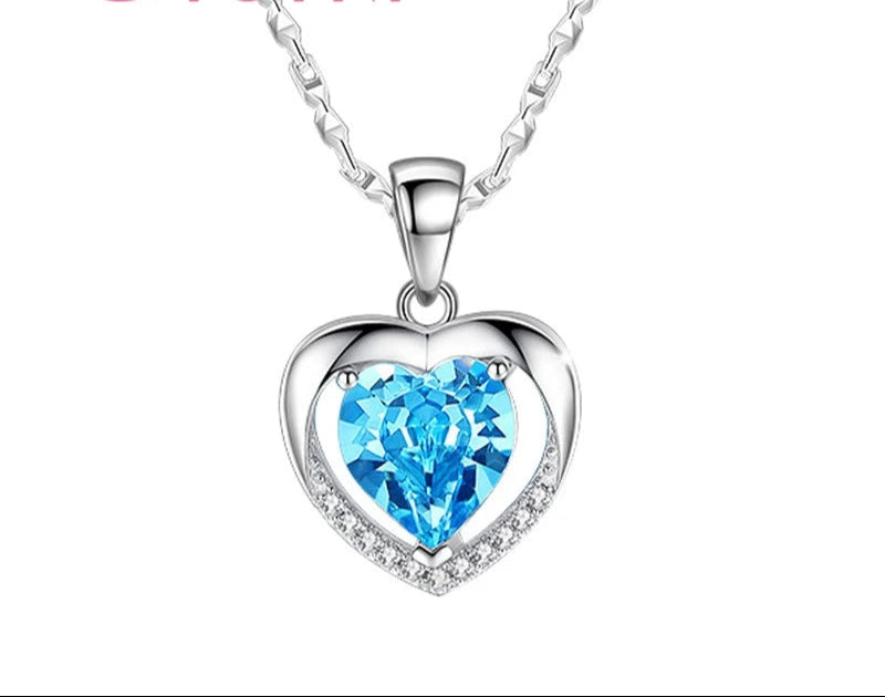 Heart-shaped necklace with blue gem and silver chain on a white background, featuring the brand 'Giemi'.