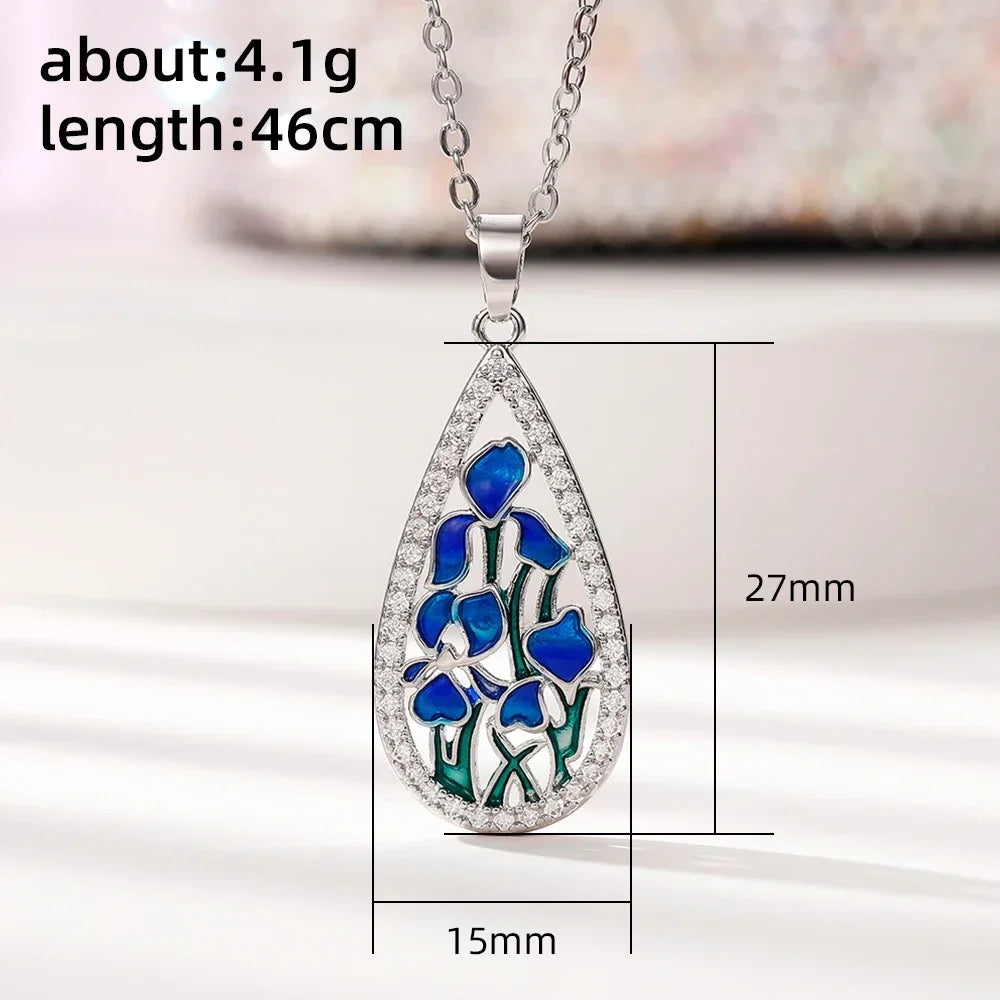 Teardrop-shaped pendant with blue floral design and measurements on a white background