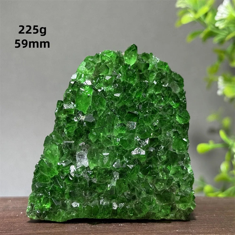 Green crystal rock on a wooden surface with a gray background