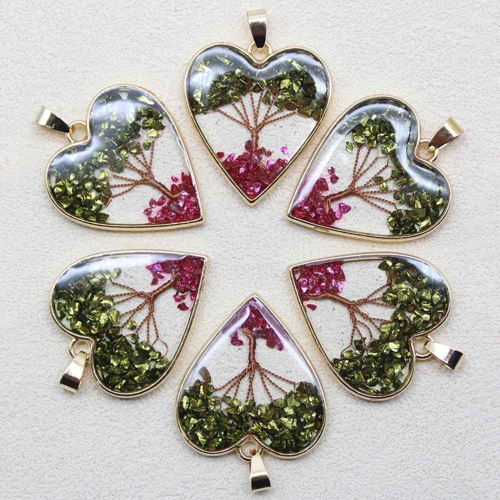 Heart-shaped pendants with green and pink leafy designs on a light gray background