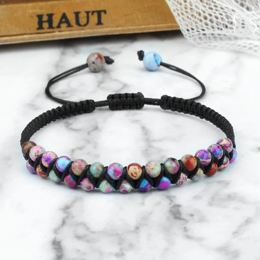 Multicolored beaded bracelet on a marble surface with 'HAUT' text in the background