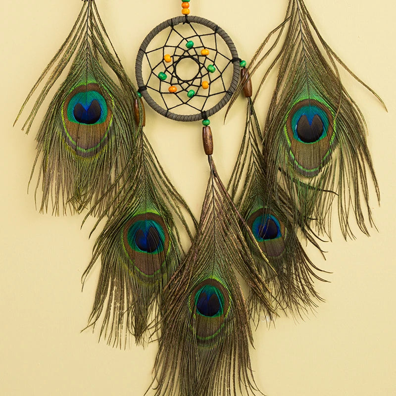 Dreamcatcher with peacock feathers on a beige background
