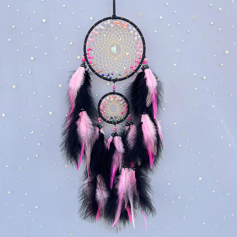 Decorative dreamcatcher with pink and black feathers on a starry background