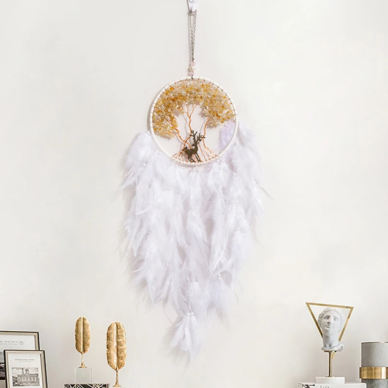 Decorative dreamcatcher with white feathers and a gold center on a light background