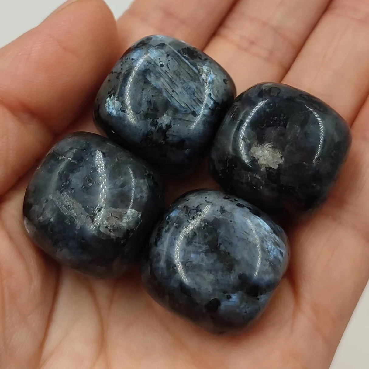 Four dark blue stones held in a hand