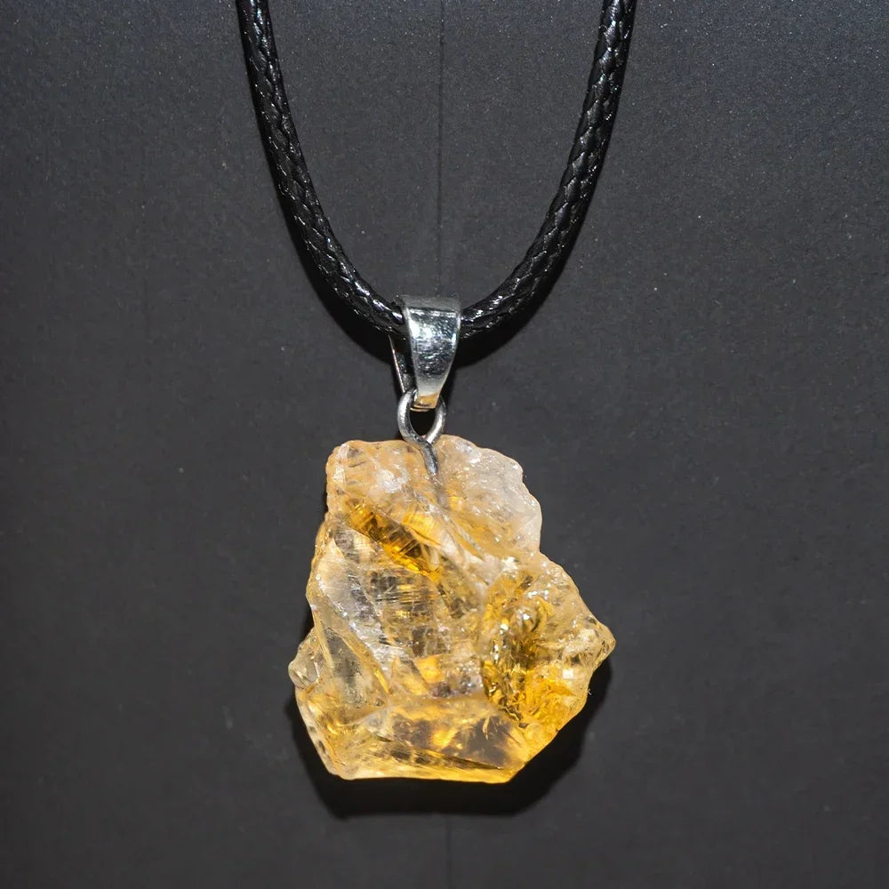 Crystal pendant on a black cord against a dark background
