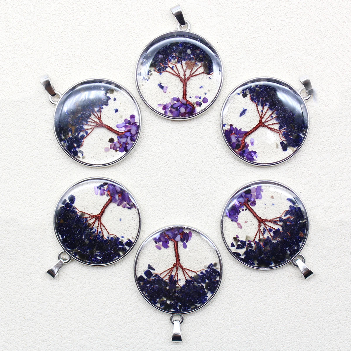 Set of six round pendants with tree designs on a white background