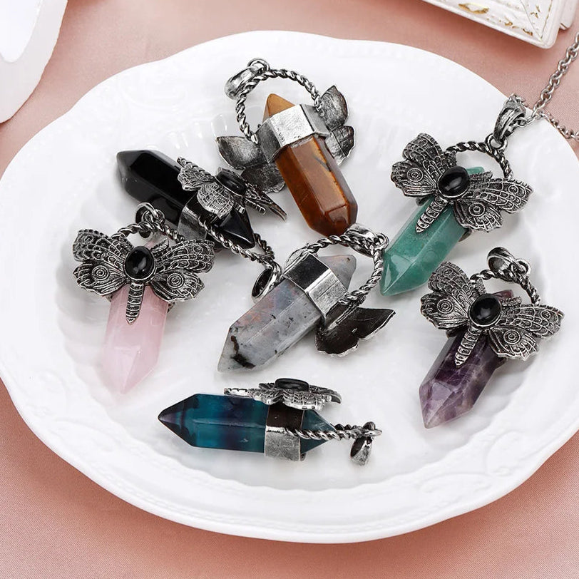 Crystal pendants on a white dish with a brand logo in the corner.