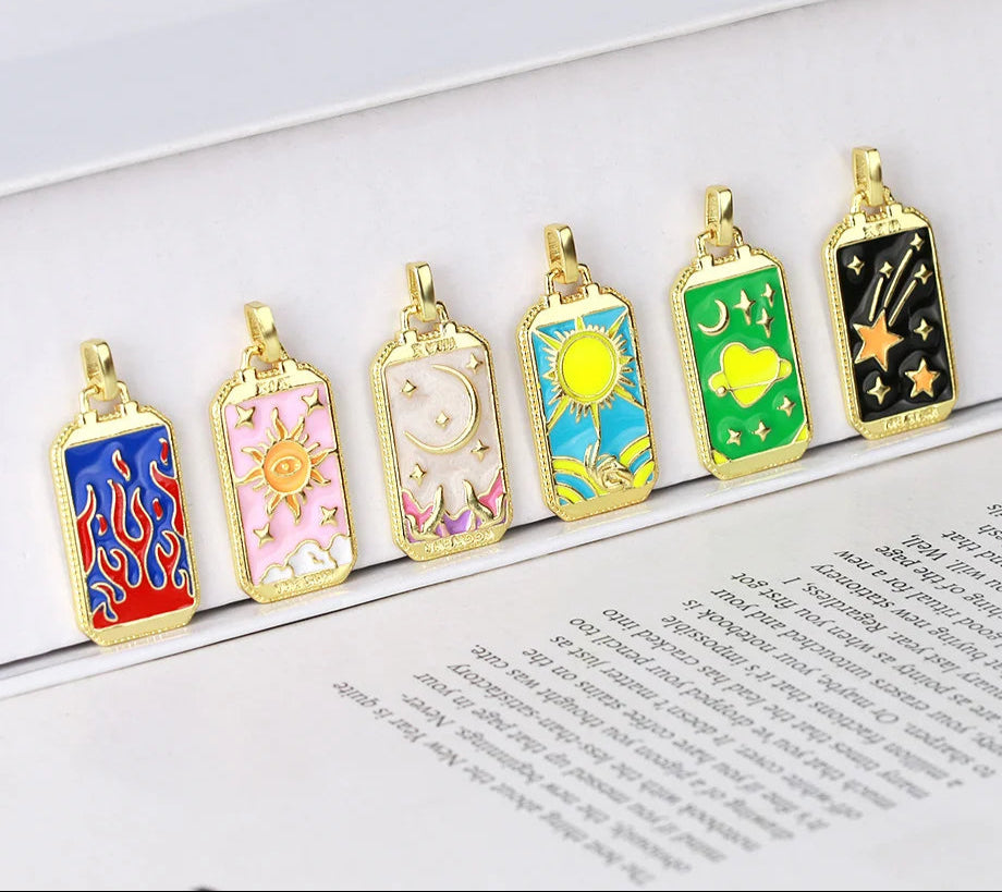 Set of colorful pendant necklaces on a book page with 'CZIA' branding.