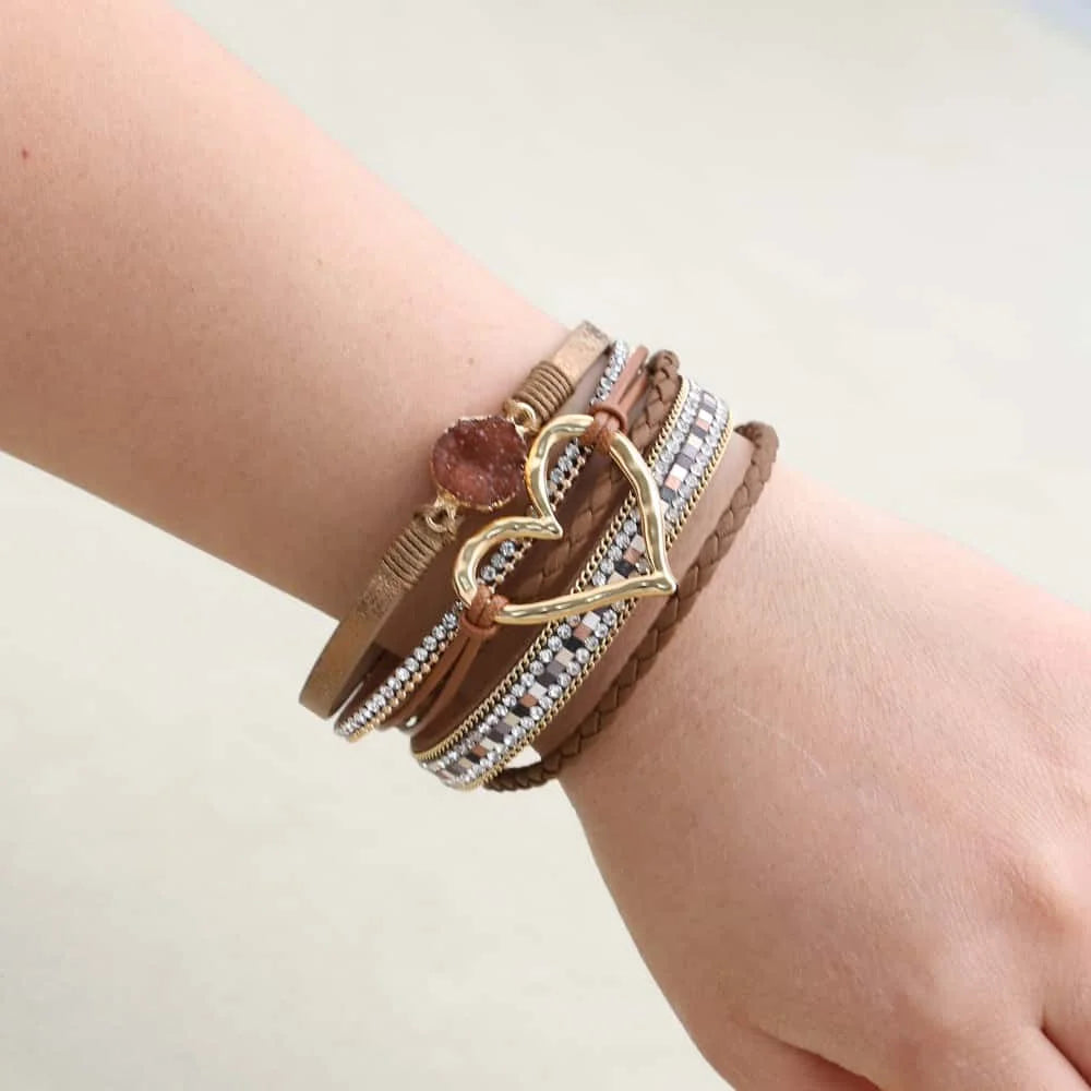 Close-up of a wrist wearing multiple bracelets on a light background