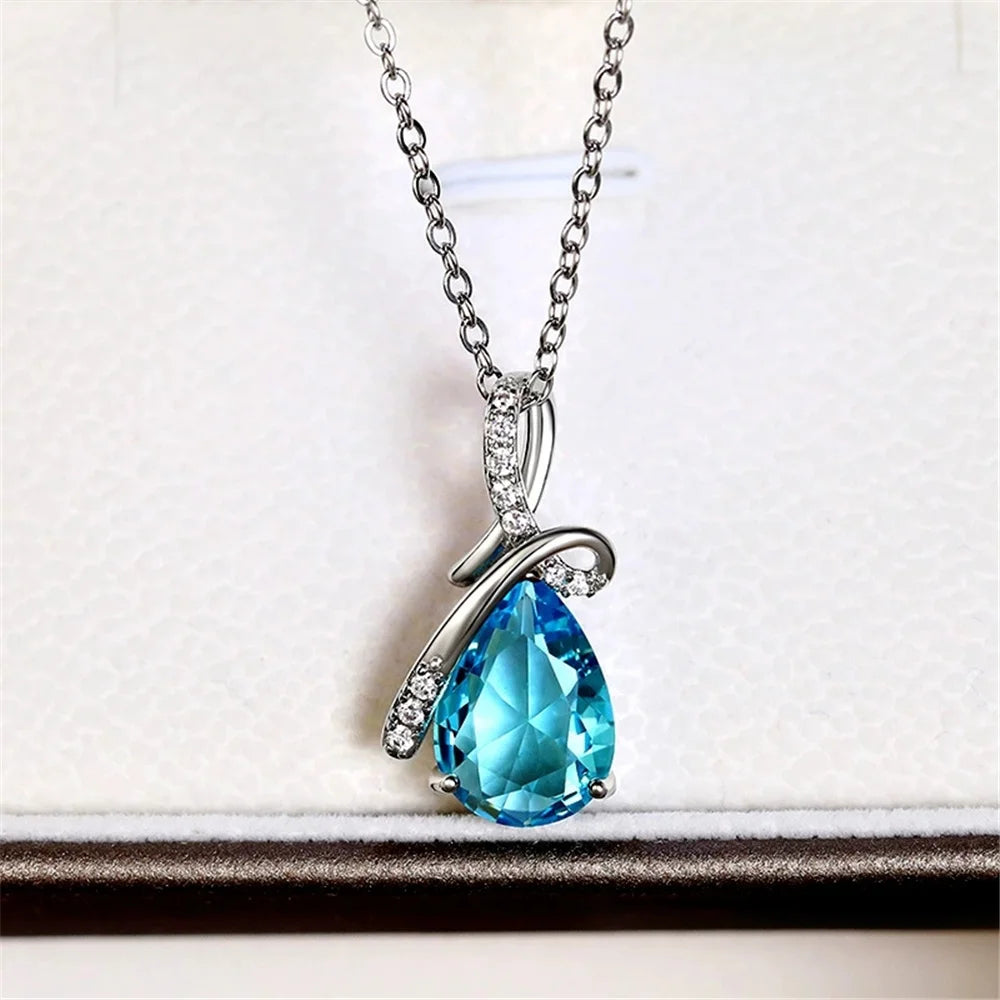 Teardrop-shaped blue gemstone necklace on a white background